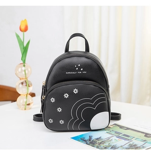 Détail d'un mini sac à dos noir avec imprimé marguerite et lettrage blanc élégant