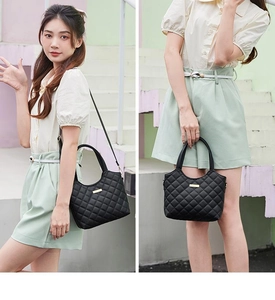 Détail d'un sac cabas matelassé noir avec boucle dorée et bandoulière en cuir