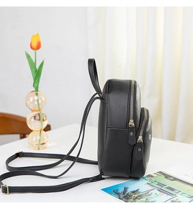 Vue latérale du mini sac à dos noir avec imprimé marguerite et fermetures éclair dorées