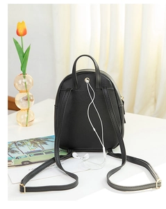 Détail de la prise casque et des boucles dorées réglables sur un mini sac à dos noir chic