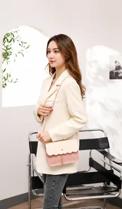 Detail der rosa-beige Patchwork-Tasche mit Wellenklappe und goldenem Kettenanhänger