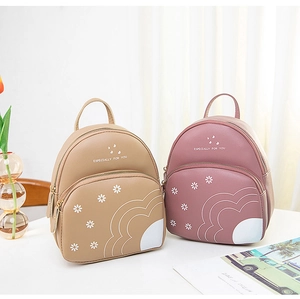 Vue détaillée des mini sacs à dos imprimé marguerite en kaki et rose avec poche frontale