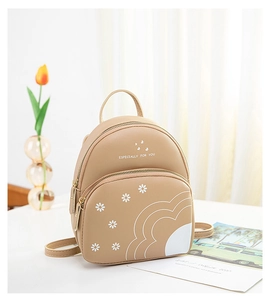 Gros plan du mini sac à dos kaki imprimé marguerite avec des détails dorés raffinés
