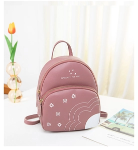 Détail d'un petit sac à dos rose avec motif floral et bretelles réglables