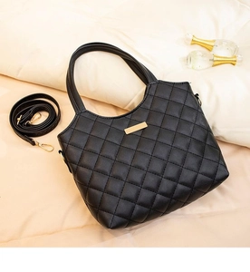 Détail du sac cabas matelassé noir avec boucle dorée et bandoulière réglable chic