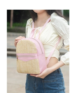 Detail of pink leather and woven straw mini backpack with gold fashion text decoration