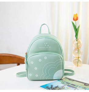 Gros plan du sac à dos vert menthe à motifs marguerites avec fermetures métalliques