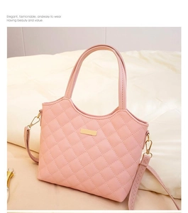 Détail du sac cabas rose matelassé avec finitions dorées et bandoulière réglable
