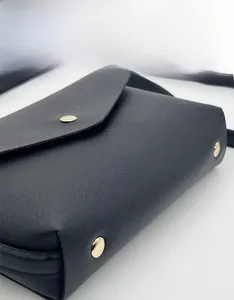 Gros plan sur la texture du similicuir noir avec boucle métallique dorée élégante