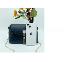 Piccola borsa a tracolla trapuntata nera con nappina a gatto e confronto con smartphone