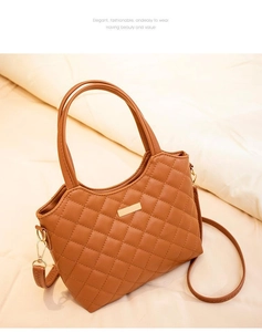 Détail du sac cabas en similicuir marron matelassé avec barre dorée et poignées