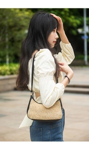 Détails d'un sac bandoulière tissé avec lanières en cuir noir et anneaux en métal en extérieur