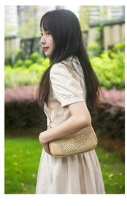 Détail de la texture tissée beige et du cuir synthétique d'un sac à bandoulière chic