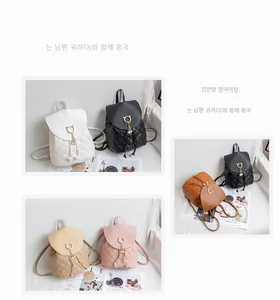 Detail of quilted leather backpacks with cat-shaped metal locks and pearl pendants