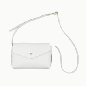 Détail du sac bandoulière en cuir PU blanc avec rabat triangulaire et boucle dorée