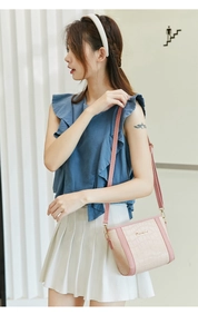 Detail der Mini-Eimertasche mit Elefantenstruktur und Sunnyday-Metalllogo für Damen