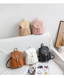 Detail of five mini quilted backpacks with cat-shaped hardware and pearl tassel charms