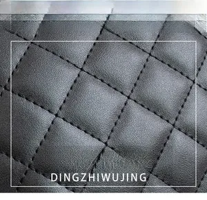 Macro shot of black quilted faux leather fabric with detailed diamond stitching patterns
