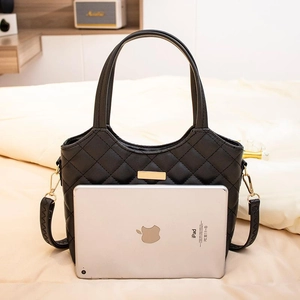 Sac fourre-tout noir matelassé avec boucle dorée et bandoulière montrant la taille