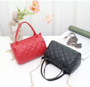 Details roter und schwarzer gesteppter Zylindertaschen mit Goldkette und Handgriffen