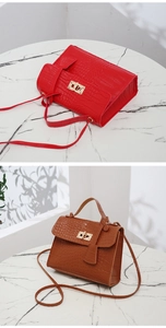 Detail of crocodile pattern leather texture and golden metal rotary lock on handbag