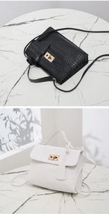 Detail of crocodile embossed crossbody bag showing gold twist lock in black and white