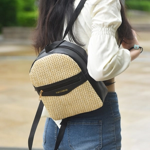 Women's woven mini backpack with natural straw and black leather patchwork design