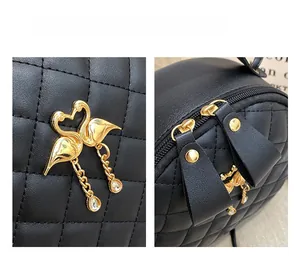 Detail of quilted leather bag featuring gold swan hardware and smooth dual zippers