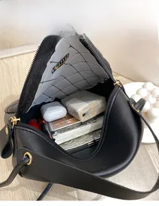 Interior view of black quilted crossbody bag showing storage for makeup and accessories