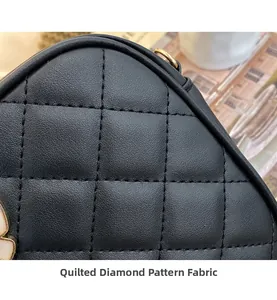 Macro detail of plump quilted diamond leather fabric on a black crossbody handbag