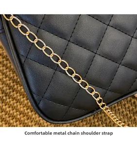 Detail of black quilted leather handbag with gold metal chain shoulder strap