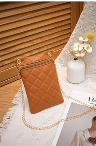 Detail der braunen gesteppten Kunstleder-Handytasche mit goldenem Reißverschluss und Kette