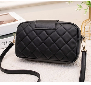 Détail du sac bandoulière noir matelassé avec ferrures dorées et finition élégante mate
