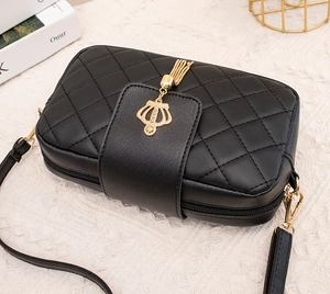 Détail du sac à bandoulière noir matelassé avec gland couronne doré et double zip