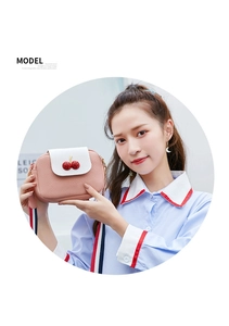Detailed view of pink and white crossbody bag with 3D cherry and striped strap
