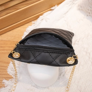 Schwarze gesteppte Mini-Kettentasche mit Gold-Hardware, offen auf Lifestyle-Hintergrund