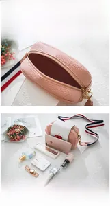 Detail showing pink cherry camera bag interior capacity for phone and cosmetics