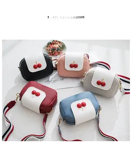 Flat lay of small crossbody bags in five colors with cherry accents and striped straps