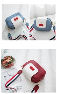Detail of crossbody camera bags with cherry accents and striped fabric shoulder straps