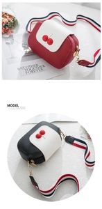 Detail of mini cherry square bags with lychee grain texture and striped shoulder straps