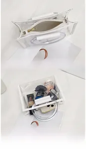 Detailed view of white PVC transparent handbag with inner zipper pouch and round handle