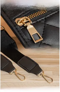Détails du cuir matelassé noir et des ferrures dorées brillantes sur le sac bandoulière