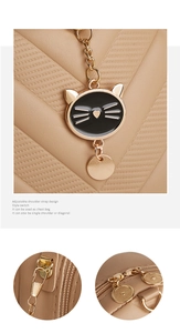 Detail of khaki leather square bag with black cat pendant and gold dual zipper hardware