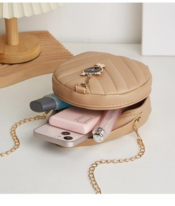 Top view showing internal capacity of the quilted beige crossbody bag with cat charm