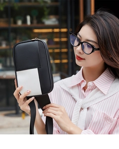 Détail du sac bandoulière en cuir contrasté noir et blanc avec fermeture éclair en haut
