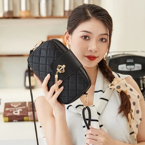 Sac bandoulière matelassé avec pompon couronne dorée et chaîne sur un mannequin