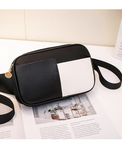 Détail du sac à bandoulière contrasté noir et blanc avec tirette dorée ronde