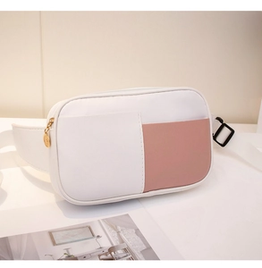 Détail d'un sac bandoulière bicolore avec zips dorés et bandoulière réglable