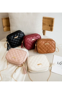 Detail of quilted leather crossbody bags with gold chain straps and stylish tassels
