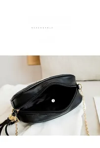 Detail of the main compartment and interior lining of the black quilted chain bag